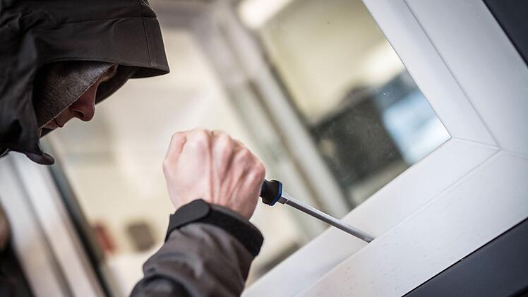 Ein Mann demonstriert in einer polizeilichen Beratungsstelle, wie einfach es für einen Einbrecher wäre, mit Hilfe eines stabilen Schraubenziehers ein geschlossenes Fenster von außen zu öffnen. Foto: Frank Rumpenhorst, dpa