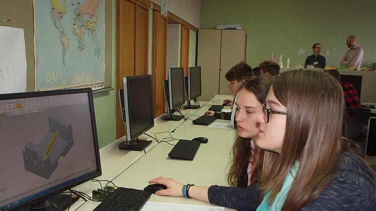 Im Rahmen des Arbeitskurses "Technischer Produktdesigner" konstruiert hier die 14-jährige Schülerin Anna Hofmann (vorne) der Herzog-Otto-Mittelschule unter Anleitung der Auszubildenden Larissa Eller (hinten) ein Bauteil am PC. Foto: Alfred Thieret