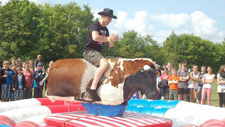 Dem Lehrer Kai Brückner gelingt es recht gut Balance auf den Bullen zu halten. Andere waren da nicht so geschickt bei dieser "Strafaktion". Foto: Gabi Arnold