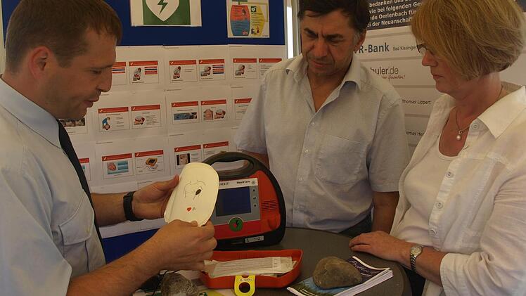 "Leben retten mit einem Defibrillator": Die Feuerwehr Ebenhausen verfügt über dieses Gerät, das 1. Kommandant Sebastian Wetzel (links) auf unserem Foto Elisabeth Mehn und Johannes Kessler erklärt. Fotos: Stefan Geiger