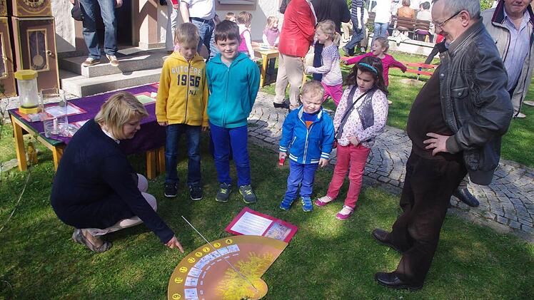 Eine vor dem Pfarrhaus errichtete Sonnenuhr zeigte den veränderlichen Stand der Sonne am Himmel als Tageszeit an. Mit im Bild ist (links) Diana Löffler vom Kita-Team, die die Vorbereitung und Durchführung des Themas: "Der Zeit auf der Spur" mit viel Engagement übernommen hatte. Ebenso ist (rechts) im Bild Pater Wladyslaw Poddebniak.