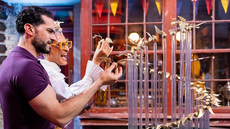 Jozef Youssef und Carla Hall begutachten die essbaren Goldenen Schnätze, die ein Team im Backwettbewerb eingereicht hat.