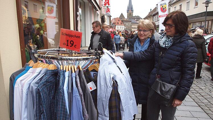 Diese beiden Frauen schauen sich das Angebot an einem Modegeschäft an.