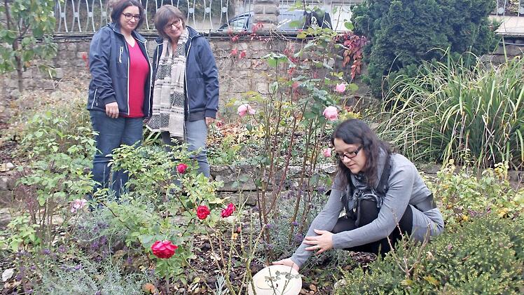 Tierbestatterin Stefanie Trum (rechts) platziert im Garten einen Gedenkstein für ein verstorbenes Tier. Ihre Mitarbeiterinnen Lendita Krasniqi (links) und Simone Schenk (mitte) waren ursprünglich selbst Kundinnen und unterstützen Stefanie Trum gerne.  Foto: Jutta Rudel