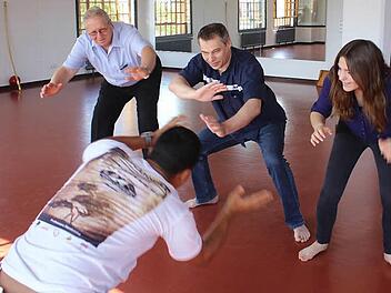 Kämpfen, Kultur und Musik vereint die Bewegungssportart Capoeira aus Brasilien. Luis Claudio Cerqueira brachte Zweitem Bürgermeister Günter Schulz, VHS-Mitarbeiter Thomas Reimer und der neuen Auszubildenden Jasmin Reinhardt (von links) die ersten Bewegungen bei.  Foto: Andreas Dorsch