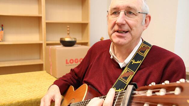 "Gute Nacht Freunde, es ist Zeit f&uuml;r mich zu gehen", spielt und singt Pfarrer Joachim Pennig auf seiner Gitarre. Die ausger&auml;umten Regale im Hintergrund sind Zeichen der Aufbruchstimmung, die derzeit im M&uuml;nnerst&auml;dter Pfarrhaus herrscht. Foto: Heike Beudert