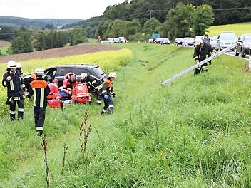 Viele Helfer mühten sich um den verletzten Mercedes-Fahrer. Im Hintergrund ist die "Abflugschneise" zu erkennen. Foto: Ralf Kestel