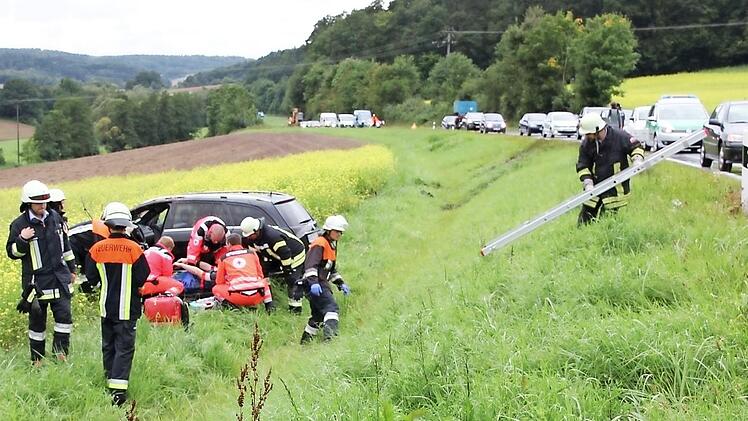 Viele Helfer mühten sich um den verletzten Mercedes-Fahrer. Im Hintergrund ist die "Abflugschneise" zu erkennen. Foto: Ralf Kestel