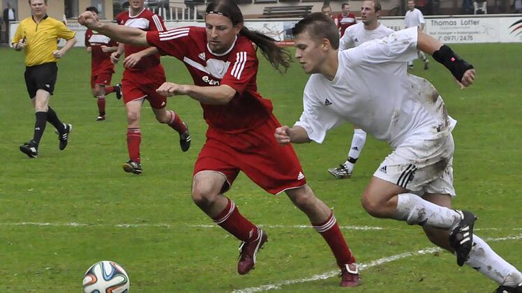 Tempo aufnehmen: Marc Lauter (rechts) von der gastgebenden TSVgg Hausen legt den Ball bei diesem Angriff am Eltingshäuser Andreas Metzler (links) vorbei. Foto: Anja Schmitt