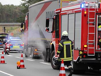 Dampf steigt auf, als Feuerwehrkräfte aus Höchstadt die überhitzte Lkw-  Achse herunterkühlen. Ein überhitzter Reifen eines Lkw verursachte eine kurzzeitige Teilsperrung der B505 bei Pommersfelden. Foto: Christian Bauriede