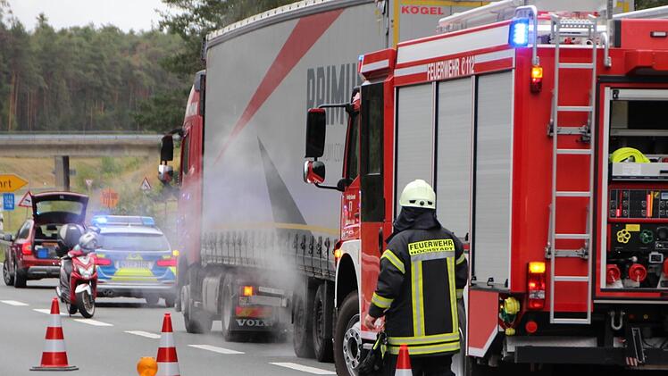 Dampf steigt auf, als Feuerwehrkräfte aus Höchstadt die überhitzte Lkw-  Achse herunterkühlen. Ein überhitzter Reifen eines Lkw verursachte eine kurzzeitige Teilsperrung der B505 bei Pommersfelden. Foto: Christian Bauriede