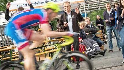 Produktmanagerin Birgit Reichart (rechts) vom Sponsor Kulmbacher Brauerei feuert im Start-Ziel-Bereich die Radsportler an.