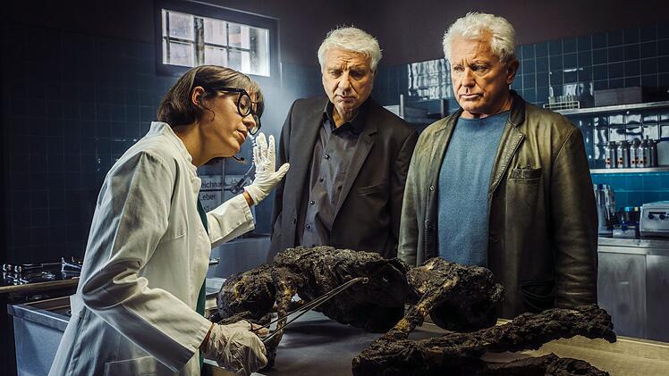 Die Kabarettistin Eva Karl Faltermeier schl&uuml;pft zum "Tatort"-Anschied von Kriminalhauptkommissar Franz Leitmayr (Udo Wachtveitl, Mitte) und Kriminalhauptkommissar Ivo Batic (Miroslav Nemec) in die Gastrolle der Rechtsmedizinerin Dr. Roswitha Schwarz-Fischer.