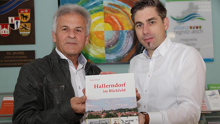 Hans Schaub (l.) übergibt das erste druckfrische Exemplar an Bürgermeister Torsten Gunselmann. Foto: Mathias Erlwein