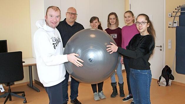 Die Gymnasiastin Kim Krappmann (rechts) unternimmt hier unter den Blicken von Einrichtungsleiter Tilo Stadelmann sowie der Sch&uuml;lerinnen Chiara Kreier, Lucy Backert und Hannah Manke eine psychomotorische &Uuml;bung mit einem Klienten (links).  Foto: Alfred Thieret