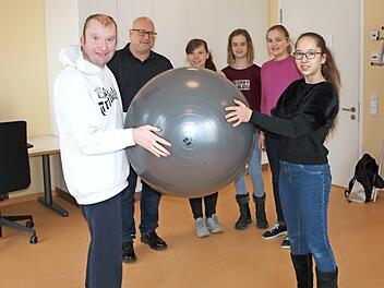 Die Gymnasiastin Kim Krappmann (rechts) unternimmt hier unter den Blicken von Einrichtungsleiter Tilo Stadelmann sowie der Schülerinnen Chiara Kreier, Lucy Backert und Hannah Manke eine psychomotorische Übung mit einem Klienten (links).  Foto: Alfred Thieret