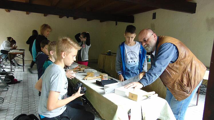 Klassenleiter Reimund Köberlein bearbeitet mit seinen Schülern die Ytong-Steine. Fotos: Petra Malbrich