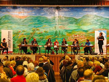 Kabarettistin Lizzy Aumeier (links) sowie Moderatorin und Redaktionsleiterin Susanne Will (rechts) fühlten den sieben Direktkandidaten in der Rhön-Festhalle auf den Zahn. Foto: Matthias Hoch