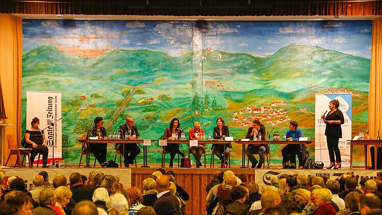 Kabarettistin Lizzy Aumeier (links) sowie Moderatorin und Redaktionsleiterin Susanne Will (rechts) fühlten den sieben Direktkandidaten in der Rhön-Festhalle auf den Zahn. Foto: Matthias Hoch