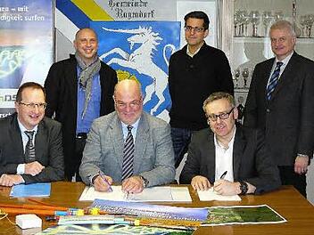 Bürgermeister Ralf Holzmann (sitzend, Bildmitte) und TMS-Geschäftsführer Peter Hornfischer (rechts) unterzeichnen die Verträge für die Errichtung des Breitband-Versorgungsnetzes im Ortsteil Losau. Mit im Bild (links) Siegbert Reuther (Net/Colsulting) sowie (hinten, von links) TMS-Projektleiter Marcus Witzel, VG-Geschäftsstellenleiter Florian Puff und Detlef Arnold vom Amt für Digitalisierung. Foto: Klaus-Peter Wulf