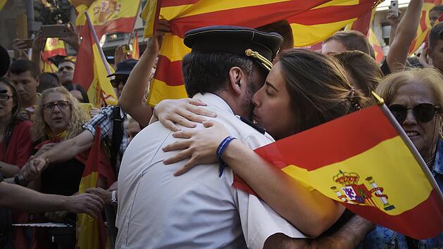 Verbundenheit mit Spanien: Eine Frau umarmt in Barcelona einen Polizisten der Guardia Civil. Foto: Danilo Balducci/ZUMA Wire/dpa