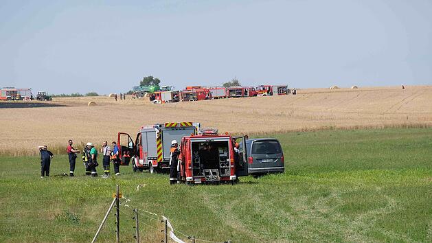 Der Brand auf einem Getreidefeld am Ortsausgang von Wartmannsroth konnte schnell gel&ouml;scht werden. Landwirte halfen mit ihren Anh&auml;ngern, das L&ouml;schwasser aus dem Teich zu transportieren.  Foto: Gerd Schaar