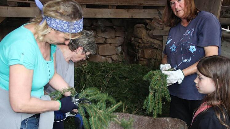 Weitgehend Frauensache ist das Binden von Girlande und Kranz. Jüngste Helferin war heuer die achtjährige Sinah. Foto:Heike Beudert