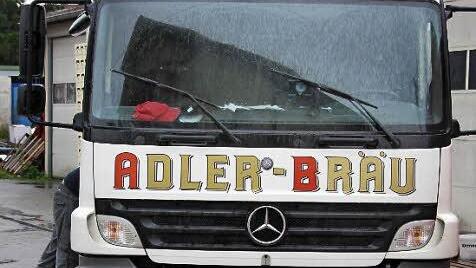 Ein Fahrer lädt den Lastwagen mit Bierkästen voll.