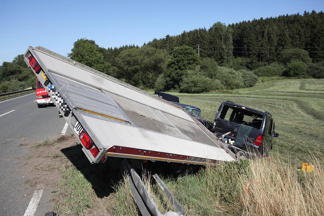 Mit Cadillac beladener Auto-Anhaenger kommt von der Fahrbahn ab