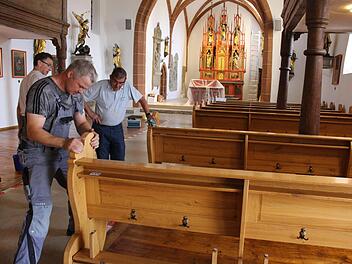 Viele Hände machen schnell ein Ende, sagt das Sprichwort. Fleißige Helfer haben die Kirchenbänke zurück in die Kirche gebracht.  Fotos: Evi Seeger