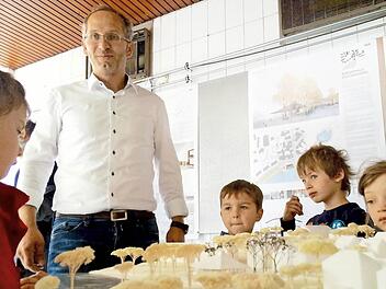 Lutz Wallenstein diskutiert mit den Kindern vom Kinderhaus Leo die Entwürfe des neuen Bürgerhauses in Wüstenahorn.
