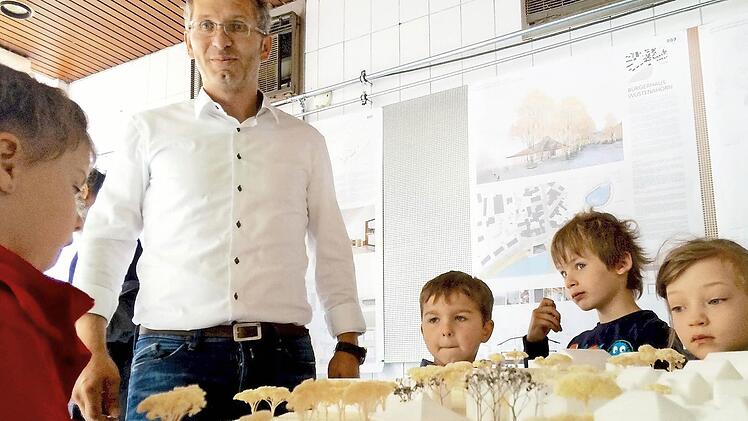 Lutz Wallenstein diskutiert mit den Kindern vom Kinderhaus Leo die Entwürfe des neuen Bürgerhauses in Wüstenahorn.