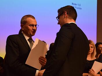 Siegmar Schnabel, Hauptgeschäftsführer der IHK zu Coburg, überreicht Florian Balke seine Ehrung als einer der besten Auszubildenden zum Kaufmann im Groß- und Außenhandel. Foto: Daniela Pondelicek