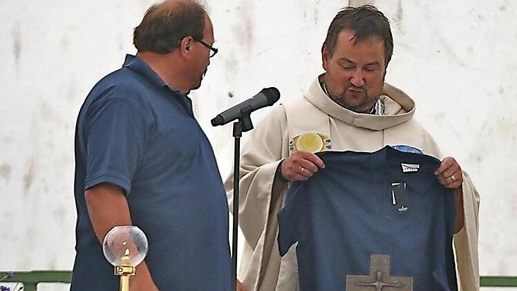 Vorsitzender Herbert Pabst (links) überreichte Pfarrer Michael Erhart ein Clubhemd der Motorradfreunde Wartmannsroth.