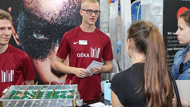 Azubi Frank Porzner von der GEKA GmbH, die in Bamberg unter anderem Kunststoff- und Metallkomponenten f&uuml;r die Medizintechnik produziert, im Gespr&auml;ch mit Besucherinnen.  Foto: RiegerPress