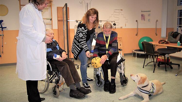 Die Patienten Karl Macht (80, rechts) und Anton Schwemmlein (90) würfeln mit Therapiehündin Fine.