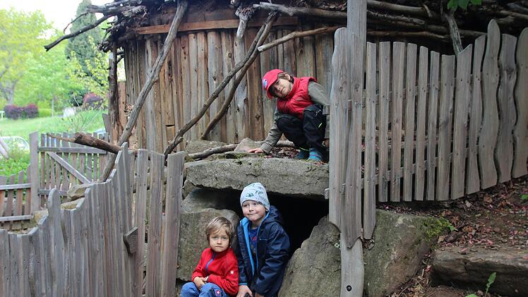 Simon Hartwich (unten links) und Simon Hillenbrand (unten rechts) schauen aus dem Eingang des Biberbaus im Kindergarten Bad Bocklet.  Ihr Freund Josef Hartwich hockt &uuml;ber den beiden. Foto: Leonie Hauck