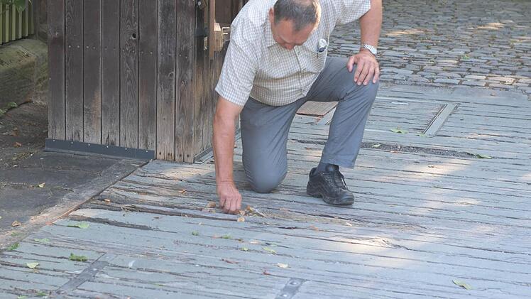 Flussmeister Albert Groh demonstriert, wie morsch etliche Balken sind: Er kann das Holz mit den Fingern lösen. Foto: Ronald Rinklef