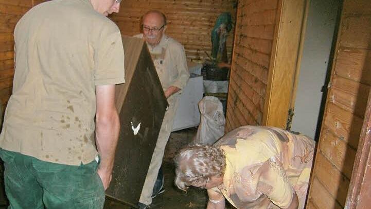 Schlimm sah es nach dem Unwetter am 2. August 2014 im Keller der Familie Kastner aus, der vollständig unter Wasser stand. Das Bild zeigt Hermann Kastner (im Hintergrund) mit Ehefrau Gerlinde und seinem Neffen Johannes Wurster bei den Aufräumarbeiten. Foto: BR-Archiv/Jürgen Gärtner