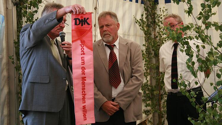 Edgar Lang vom DJK-Diözesanverband (links) übergibt Banner an Vorsitzenden Manfred Rüttinger. Foto: Gabriele Sell