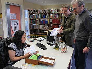 Spaß bei der Arbeit: Mandy Hassan leiht den beiden Lehrern Ulrich Bäumler und Rudolf Baumgarten Bücher aus. Fotos: Ralf Dieter