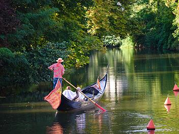 Ein Gondolier bringt in Bamberg mehrere Urlauber über die Regnitz. Foto: Nicolas Armer/dpa