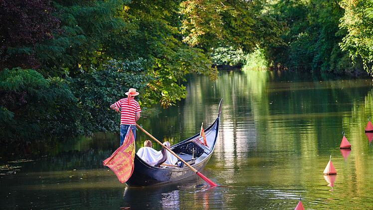 Ein Gondolier bringt in Bamberg mehrere Urlauber über die Regnitz. Foto: Nicolas Armer/dpa