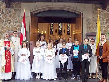 Das Bild zeigt Pater Helmut Haagen (links), die Ministranten von St. Pankratius Steinberg, die Kommunionkinder und ihre Lehrerin Petra Haida (rechts). Foto: Heike Schülein