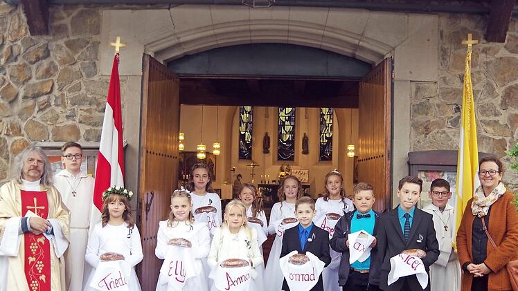 Das Bild zeigt Pater Helmut Haagen (links), die Ministranten von St. Pankratius Steinberg, die Kommunionkinder und ihre Lehrerin Petra Haida (rechts). Foto: Heike Schülein