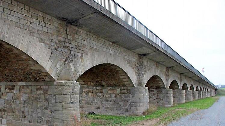 Die Flutbrücke muss in einem Spezialverfahren teilerneuert werden, der historische Unterbau soll aber erhalten werden. Zu erkennen sind auf dem Bild die offenen Fugen, an denen die Teilstücke der Fahrbahnplatte zusammengefügt wurden: Hier hat Wasser zu Schäden geführt. Die neue Fahrbahnplatte soll dann fugenlos auf der Natursteingewölbebrücke aufliegen.  Fotos: Andreas Lösch