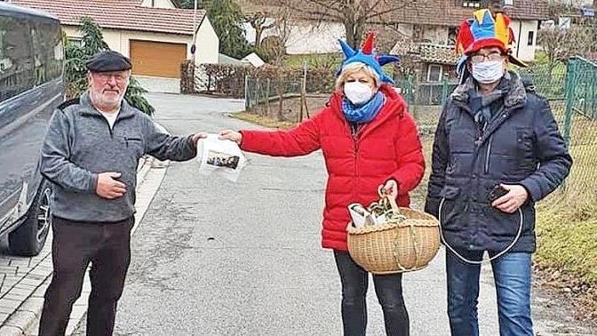 Margit und Michael Gärtlein übergeben den Faschingsgruß an Günther Seidel (links).