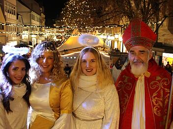 Posieren am erleuchteten Marktplatz: das Kissinger Christkind Lynnette Schmidt (zweite von links), die Engel Anna-Lena Koch (links), Isabell Voll sowie Nikolaus Udo Dickhage . Foto: Benedikt Borst