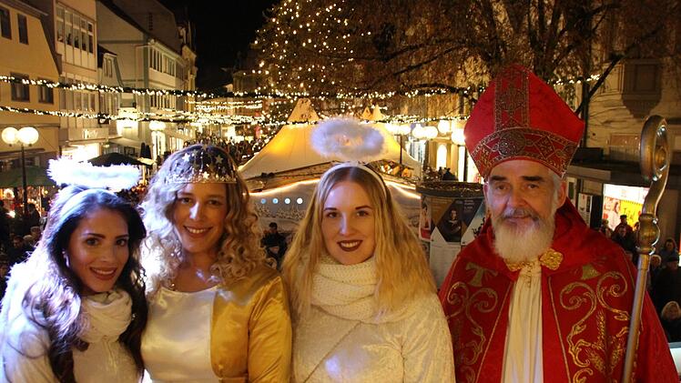 Posieren am erleuchteten Marktplatz: das Kissinger Christkind Lynnette Schmidt (zweite von links), die Engel Anna-Lena Koch (links), Isabell Voll sowie Nikolaus Udo Dickhage . Foto: Benedikt Borst