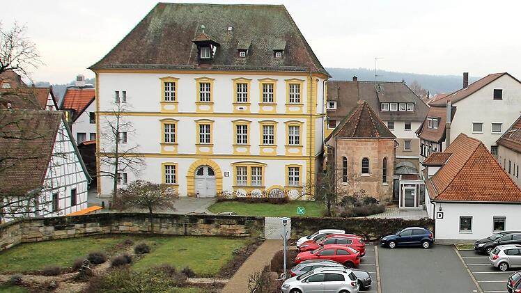 Wo heute bereits Autos parken, könnte eine Parkdeck entstehen. Der Heimatverein sieht wegen der Nähe zu dem historischen Amtshaus (links) und zur Gereonskapelle (rechts daneben) den Ensembleschutz gefährdet.  Foto: Ronald Heck